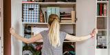 Young woman looking into her cluttered wardrobe